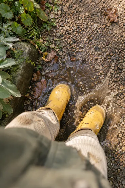 Little yellow rain boots stomping in a puddle